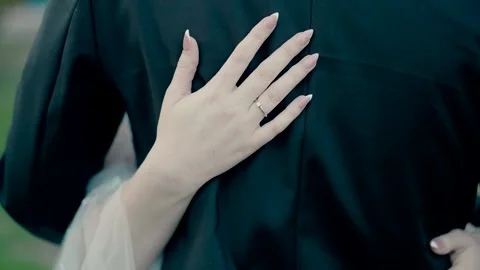 Hands of a bride on the back of the station in a black suit. Stock Footage 229480994