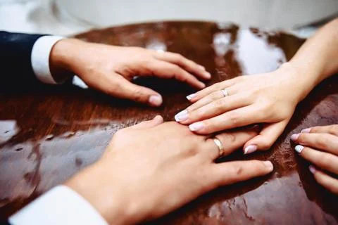 Hands of brides on a table with drops of water during the rain Stock Photos