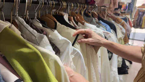 Hands Browsing Clothes on a Rack in a Second Hand Store Stock Footage 342488317