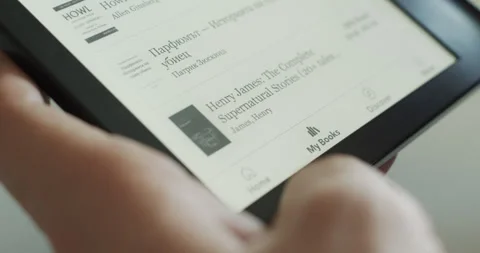 Hands browsing e-book reader device - electronic reading with e-ink display Stock Footage 279821285