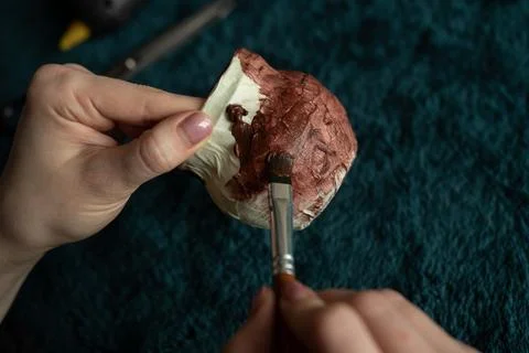 Hands with a brush cover the container with paint Stock Photos