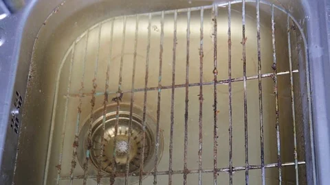 Hands brushing of the surface of a filthy grill rack in kitchen sink. Stock Footage 74891618