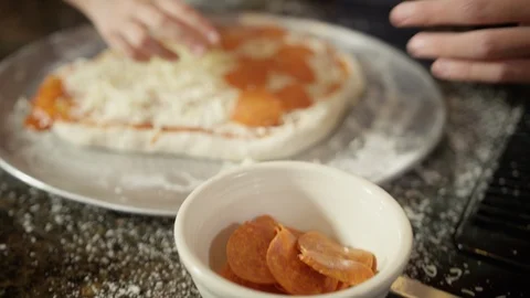 Hands building a pepperoni pizza at home in kitchen Stock Footage 123733753