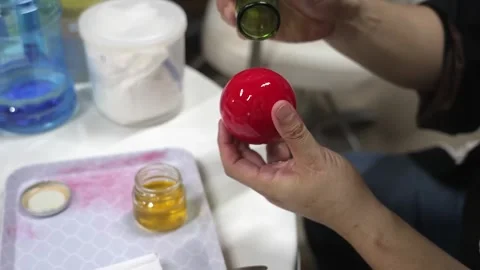Hands Burnishing a Glossy Red Sphere with a Glass Bottle Stock Footage 340901158