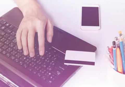 Hands of a businessman typing on a computer or laptop keyboard and holding .. Stock Photos