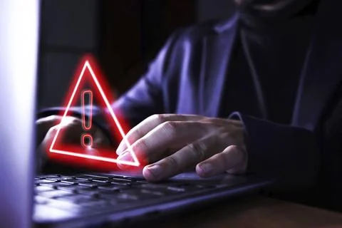 Hands of a businessman using the computer on fraudulent pages. Caution symbol of 스톡 사진