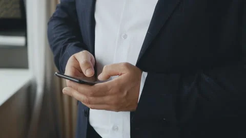 Hands of a businessman using a smartphone leafing through a news feed Stock Footage 133512295