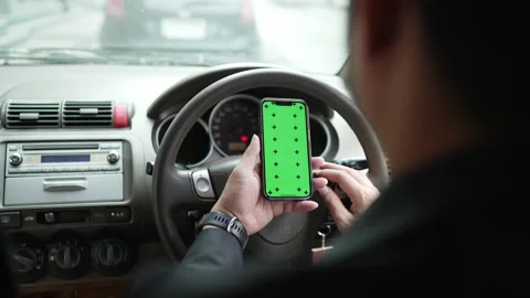 Hands of a businessman using a smartphone typing with mock-up green  in a car Stock Footage 174609854