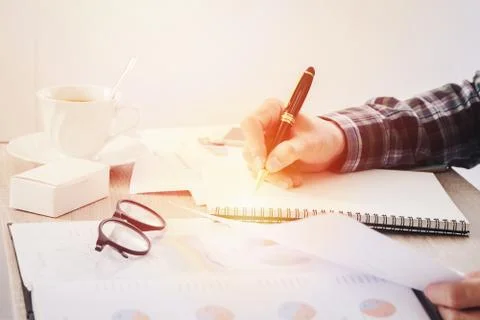 Hands of businessman writing something on notebook paper, and business finance Stock Photos