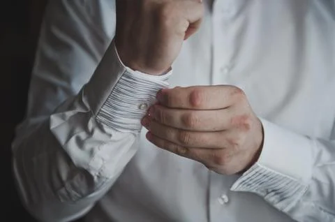 Hands button up the buttons on his shirt 7870. Stock Photos