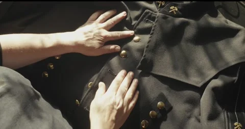 Hands Buttoning Traditional Miner's Tunic with Crossed Hammer Insignia 스톡 동영상 344347490