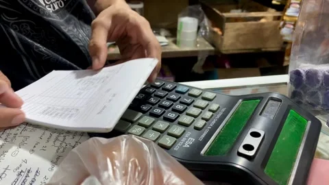 Hands Calculating Numbers and Writing Notes on Desk Stock Footage 327176040