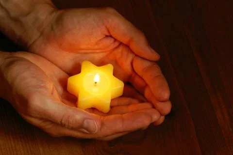 Hands with candle Stock Photos