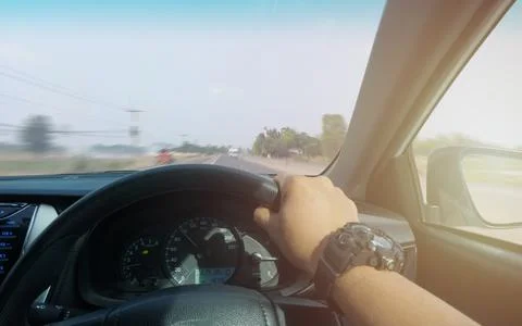 Hands of car driver on steering wheel, fast limit 100 Km/h driving car at hol Stock Photos