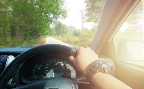 Hands of car driver on steering wheel, fast limit 100 Km/h driving car at hol Stock Photos