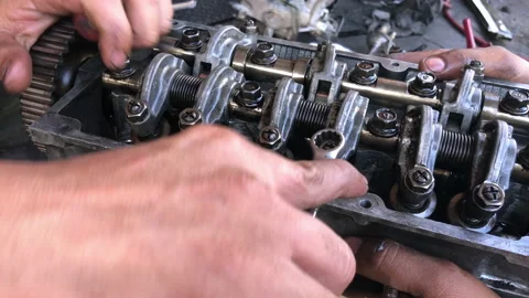 Hands on Car Engine Block petrol gasoline cylinder cam shaft spring rocker arm v Stock Footage 133519387