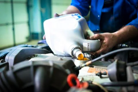 Hands of car mechanic with a bottle of engine oil Stock Photos