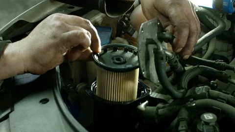 The hands of a car mechanic insert an oil filter into the car Stock Footage 124313686