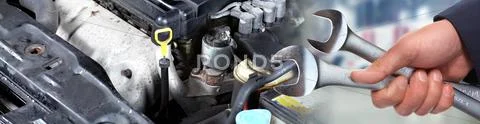Hands of car mechanic with wrench in garage. Stock Photos