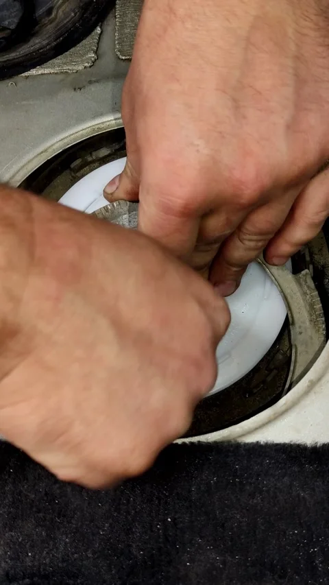 Hands carefully guide colorful hoses into a car fuel tank Video stock 335834617