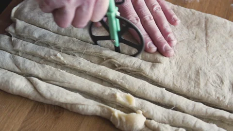 Hands carefully slicing soft rolled dough. Stock Footage 331851478