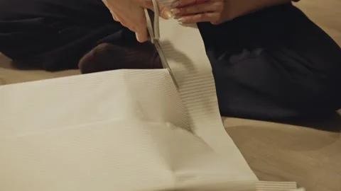 Hands Carefully Trim Striped Wrapping Paper to Neatly Finish a Christmas Gift - Stock Footage 332684124