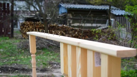 Hands of carpenter affixing pine wood banisters to a plank Stock Footage 87966895