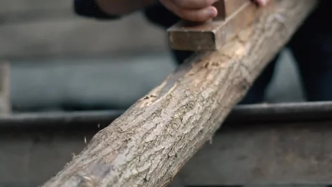 The hands of a carpenter who cut a log with a plane. The hard work of a handy Stock Footage 147330508