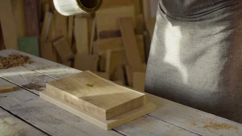 Hands of carpenter woodworker pouring lacquer on a wooden plank Stock Footage 76102319