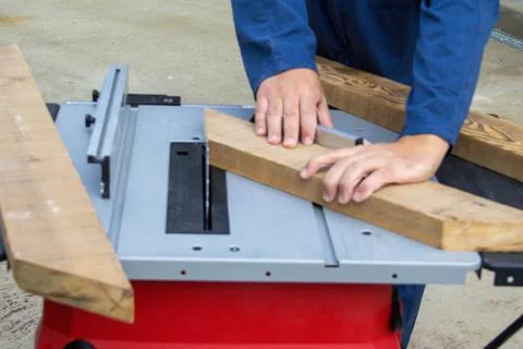 Hands of carpenter at work while cutting wood Foto stock