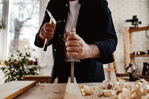 Hands of a carpenter working with chisel and hammer Stock Photos