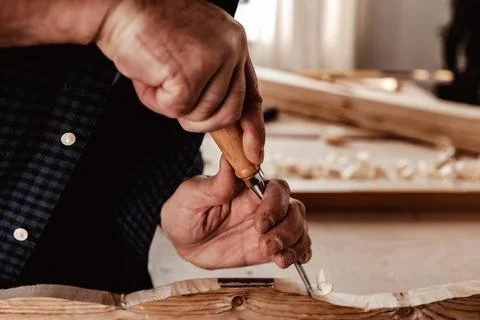 Hands of a carpenter working with chisel and hammer Stock Photos