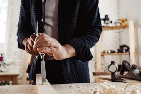 Hands of a carpenter working with chisel and hammer Stock Photos