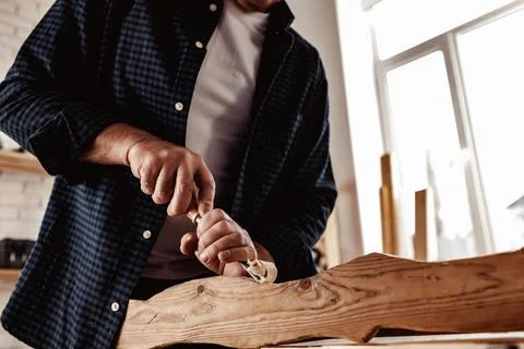 Hands of a carpenter working with chisel and hammer Stock Photos