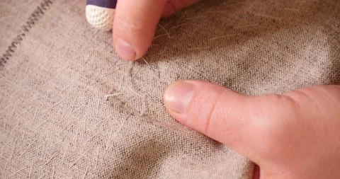 Hands of caucasian man : white threads, the needle on the background of linen Stock Footage 130467871