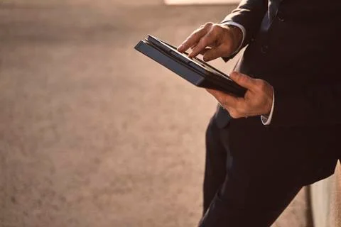 Hands of a caucasian senior CEO using a smartphone and smart tablet Stock Photos