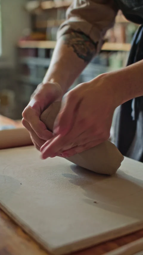 Hands of Ceramist Kneading Clay on Table in Pottery Workshop Stock Footage 319224036
