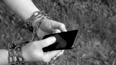 Hands in chains hold a smartphone Stock Footage 137228795