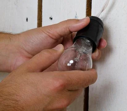 Hands changing light bulb at home Stock Photos