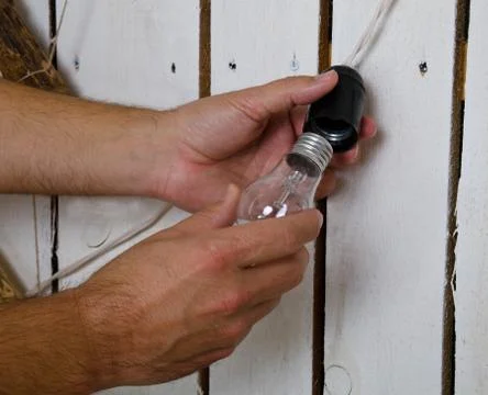Hands changing light bulb at home Stock Photos