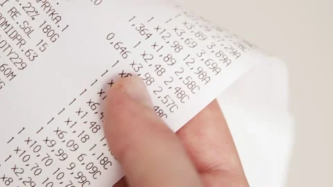Hands checking grocery receipt or bill after grocery shopping at a supermarket. Stock Footage 143781722