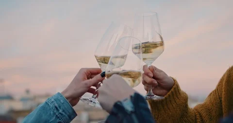 Hands cheering with glasses of white wine during the golden hour Stock Footage