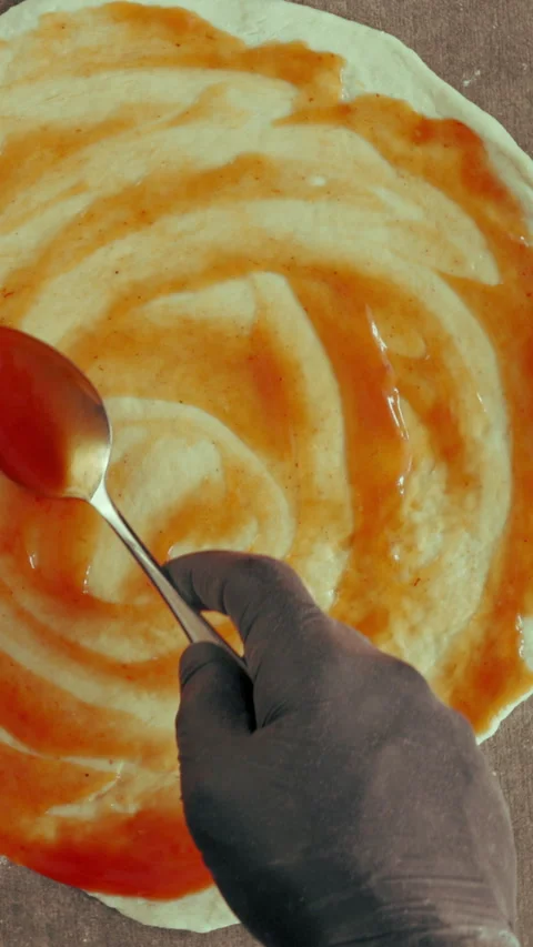 Hands, chef and sauce in bakery for pizza dough, baking and cooking or catering 库存影片 340451299