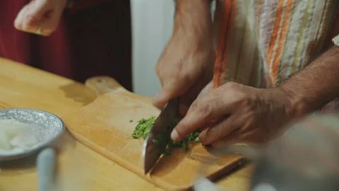 Hands of Chef Chopping Fresh Herbs on Cutting Board in Kitchen Stock Footage 303014122