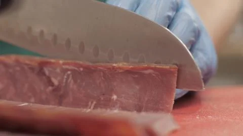 Hands chef cook using knife for cutting meat while cooking in kitchen close up Stock Photos