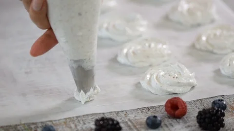 Hands of a chef cooking meringue in the kitchen. Pastry tube spread meringue on Stock Footage
