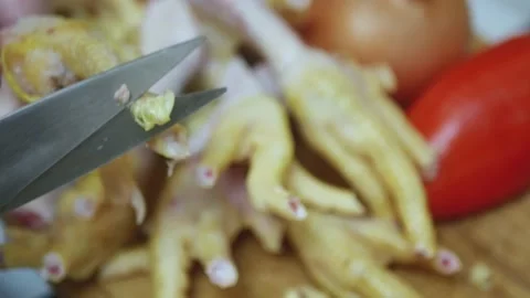 The hands of the chef cut the claws on chicken feet with kitchen scissors, t Stock Footage 223525705