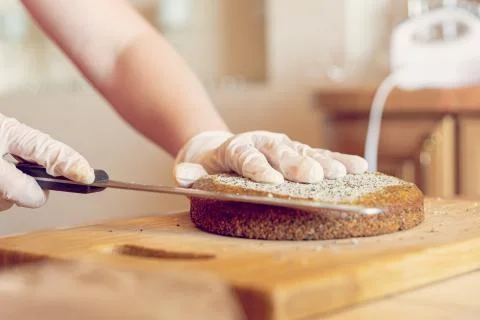 Hands chef cutting chocolate cake layers and stacking them Stock Photos