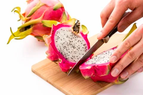 Hands of a chef cutting a dragonfruit in half Stock Photos