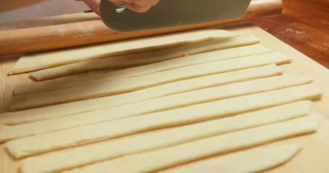 Hands of a chef cutting pastry strips for a homemade apple pie before baking Stock Footage 325887878